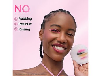 a young woman looking in the mirror applying toner or micellar water to her face with a cotton pad, seeing the micellar water benefits on her skin