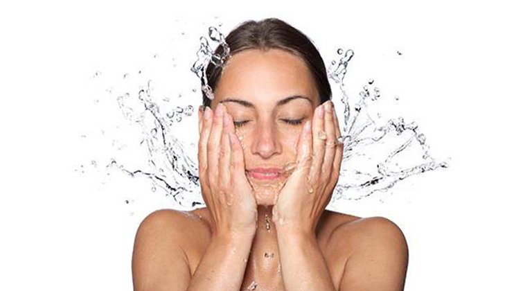 Women rinsing her face after using Garnier cleansing water