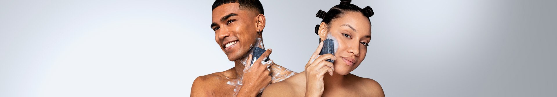 two models using charcoal bar on skin