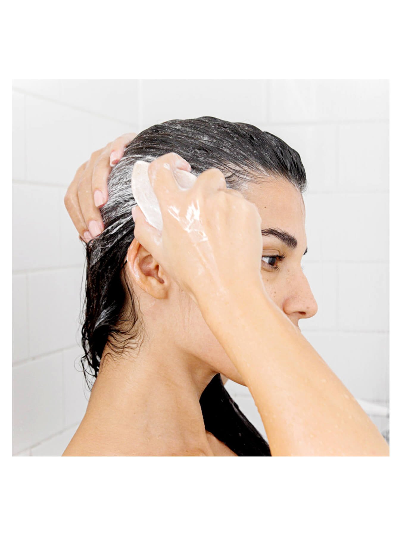 woman using marvellous oils shampoo bar